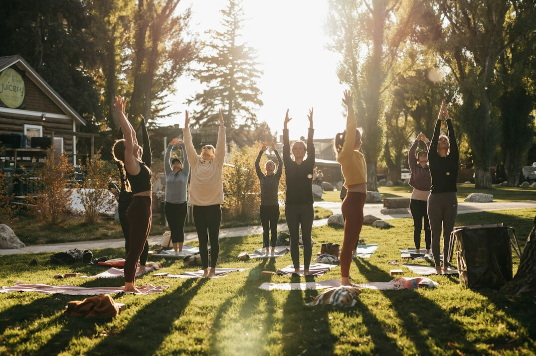 group doing outdoor yoga summer